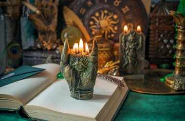 Parlayan mumların, antik tarot kartlarının, kristal kürenin ve sihirli ayin aletlerinin yer aldığı güzel düzenlenmiş bir cadı sunağı sahnesi. Bu atmosferik bileşim mistik enerjinin, ruhani uygulamanın ve esrarengiz zarafetin özünü çağrıştırıyor.