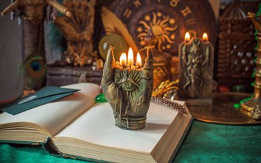 Parlayan mumların, antik tarot kartlarının, kristal kürenin ve sihirli ayin aletlerinin yer aldığı güzel düzenlenmiş bir cadı sunağı sahnesi. Bu atmosferik bileşim mistik enerjinin, ruhani uygulamanın ve esrarengiz zarafetin özünü çağrıştırıyor.