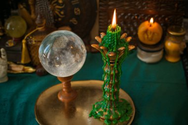 Atmosferik mistik sahne, kristal bir küre ve damlayan yeşil bir mum. Tarot okuyucular, manevi içerik veya metafizik bloglar için ideal esrarengiz titreşimler.