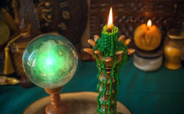 Atmosferik mistik sahne, kristal bir küre ve damlayan yeşil bir mum. Tarot okuyucular, manevi içerik veya metafizik bloglar için ideal esrarengiz titreşimler.