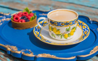 Limonlu çay fincanı ve mavi tepside tatlı, rahat bir yaşam tarzı.