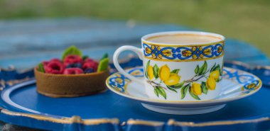 Limonlu çay fincanı ve mavi tepside tatlı, rahat bir yaşam tarzı.