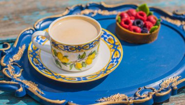 Limonlu çay fincanı ve mavi tepside tatlı, rahat bir yaşam tarzı.