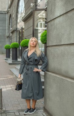 Kendine güveni tam Avrupalı bir kadın Gri montlu, Kentsel Yürüyüşün tadını çıkarıyor