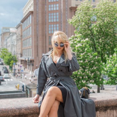 Kendine güveni tam Avrupalı bir kadın Gri montlu, Kentsel Yürüyüşün tadını çıkarıyor