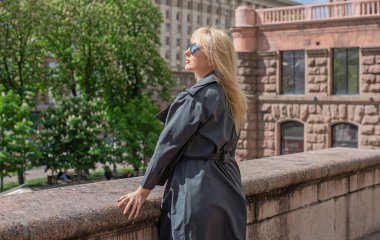 Kendine güveni tam Avrupalı bir kadın Gri montlu, Kentsel Yürüyüşün tadını çıkarıyor