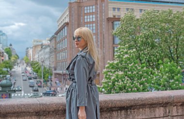 Kendine güveni tam Avrupalı bir kadın Gri montlu, Kentsel Yürüyüşün tadını çıkarıyor