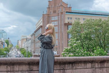 Kendine güveni tam Avrupalı bir kadın Gri montlu, Kentsel Yürüyüşün tadını çıkarıyor