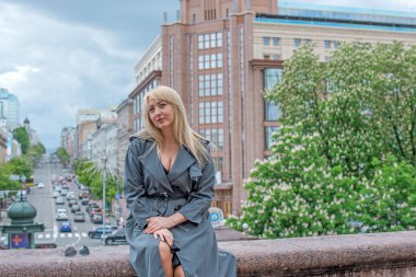 Kendine güveni tam Avrupalı bir kadın Gri montlu, Kentsel Yürüyüşün tadını çıkarıyor