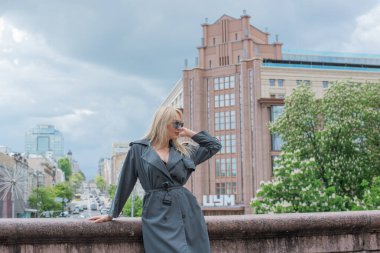 Kendine güveni tam Avrupalı bir kadın Gri montlu, Kentsel Yürüyüşün tadını çıkarıyor