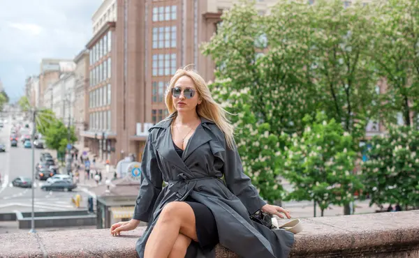 Kendine güveni tam Avrupalı bir kadın Gri montlu, Kentsel Yürüyüşün tadını çıkarıyor