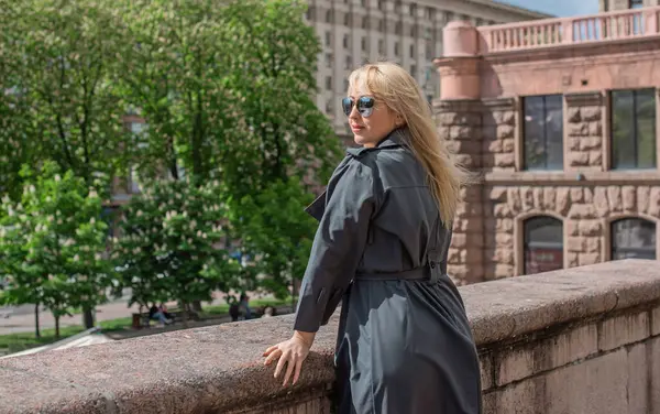 Kendine güveni tam Avrupalı bir kadın Gri montlu, Kentsel Yürüyüşün tadını çıkarıyor