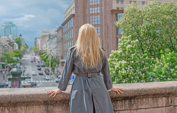 Kendine güveni tam Avrupalı bir kadın Gri montlu, Kentsel Yürüyüşün tadını çıkarıyor