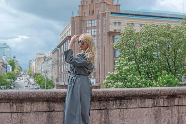 Kendine güveni tam Avrupalı bir kadın Gri montlu, Kentsel Yürüyüşün tadını çıkarıyor