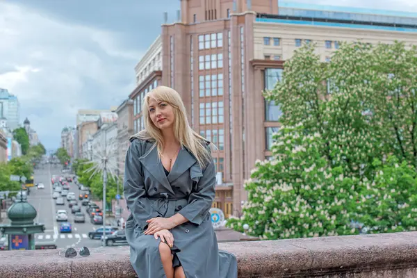 Kendine güveni tam Avrupalı bir kadın Gri montlu, Kentsel Yürüyüşün tadını çıkarıyor