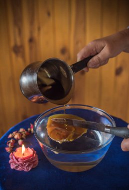 Balmumu dökme ayini. Aura 'nın Enerjik Temizliği. Eriyen balmumu, sembolik şekillerde katılaşır, serbest bırakılan duygusal ve ruhsal tıkanıklıkları yansıtır.