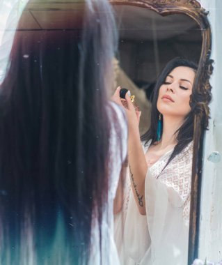 Esmer bir kadın, bembeyaz bir elbise, zarafet portresi, dayanıklılık ve güzellik sarılmış, sabah ışığında sessizce durur 