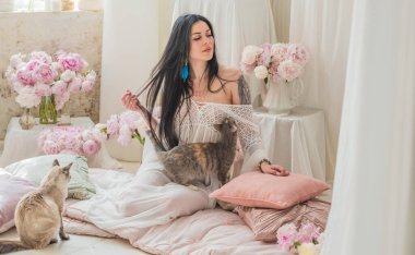 Esmer bir kadın, bembeyaz bir elbise, zarafet portresi, dayanıklılık ve güzellik sarılmış, sabah ışığında sessizce durur 