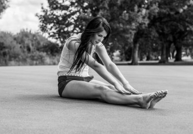 Şehir parkında egzersiz. Bayan dışarıda egzersiz yapıyor. Sağlıklı yaşam tarzı kavramı. Atletik genç kadın portresi doğal olarak dinleniyor. Güneşli bir günde parkta güzel bir kadın.