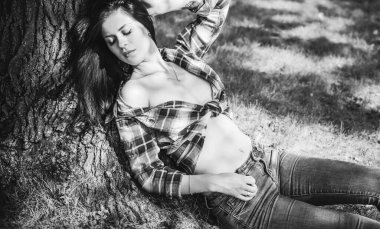 Ekose gömlek ve kot pantolon giymiş güzel bir kızın kır tarzı portresi. Amerikan tarzı, modern trend