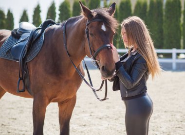 Atlı bir kız, kırsal bir yer, atıyla konuşan bir kadın. Rancho 'da bir kadınla ata binmenin portresi.
