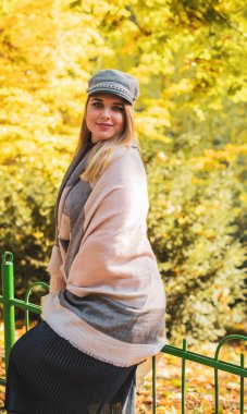 Mutlu gülümseyen güzel ve büyük beden modeli. Güneşli bir günde gülümseyen büyük kızı kapatıyoruz. Yeni çağ güzelliğinin fotoğrafı, sonbahar zamanı.