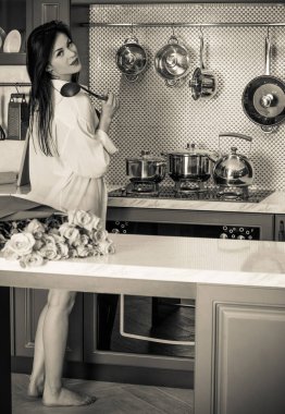 Modern bir mutfaktaki çekici seksi Avrupalı kadın iç çamaşırı giyer ve iç mekanda kendini iyi hisseder.