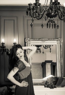 Evin içinde poz veren zayıf vücutlu çekici bir bayan. Baştan çıkarıcı seksi esmer kadınlar, doğal Avrupa klasik güzelliği.