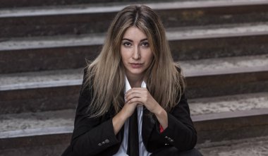 Beyaz gömlekli, siyah kravatlı, okul ceketli, Millennials tarzı asi bir genç. Eski okul ceketli üniversiteli asi kız, 90 'lı yılların kampüs tarzı portresi.