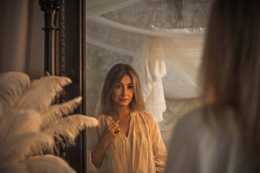 Antika iç mimari bölümündeki klasik kadın ince dantelli, antika bir bluz giyer. Eski moda bir estetik.