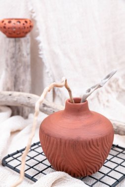 Farklı ağaç dalları ve arka planda pamuk bej kumaşlı bej kumaşları olan natürmort. Dikey