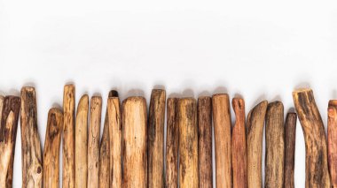 Beyaz arkaplanın alt kenarı boyunca sıralanmış tahta çubuklar tasarım veya metin için boş alan bırakırlar. Minimalist planlar, doğal temalar ya da soyut sanat projeleri için mükemmel.