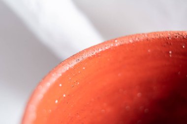 Terracotta fincan tabağının yakın çekimi, parlak iç yüzeyden parlak iç kısma benzersiz geçişi vurguluyor, dokuyu ve işçiliği vurguluyor