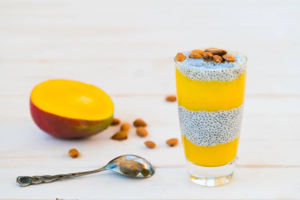 Chia seed pudding, mango puree and coconut milk. The concept of a healthy breakfast, vegan, raw food desserts without sugar. Gray background, copy space. Selective focus.