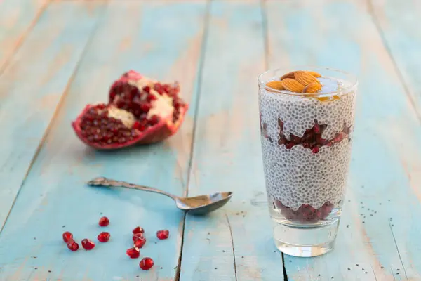 Pudding with pomegranate and chia seeds. The concept of a healthy breakfast, vegan, raw food desserts without sugar. Blue background.