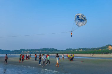 Parasailing ekstrem sporları mavi arka planda plajda. İnsanlar mavi gökyüzünde paraşütle atlıyor. Denizin üstündeki açık gökyüzünde paraşütle atlıyor..