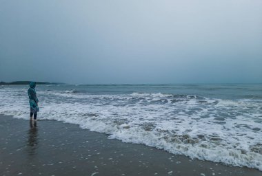 Güneşin, özgürlüğün ve hayatın tadını çıkaran rahat bir kadın. Gün batımında güzel bir kumsal. Genç bayan kendini özgür, rahat ve mutlu hissediyor. Tatil, özgürlük, mutluluk, keyif ve refah kavramı.