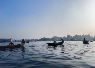 Sadarghat nehri manzarası, nehirden geçen küçük tekneler, muson yağmurlarında banliyö feribotu, Buriganga nehrinde tekne gezisi..