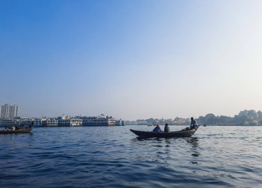 Sadarghat nehri manzarası, nehirden geçen küçük tekneler, muson yağmurlarında banliyö feribotu, Buriganga nehrinde tekne gezisi..