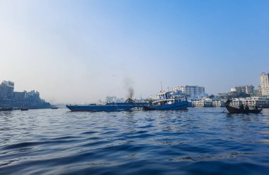 Sadarghat nehri manzarası, nehirden geçen küçük tekneler, muson yağmurlarında banliyö feribotu, Buriganga nehrinde tekne gezisi..