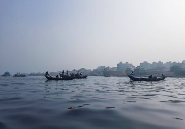 Sadarghat nehri manzarası, nehirden geçen küçük tekneler, muson yağmurlarında banliyö feribotu, Buriganga nehrinde tekne gezisi..