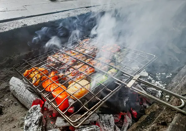 Izgarada, dumanlı ve alevli çeşit çeşit ızgara et. Barbekü şişleri yanan ızgarada sebzeli et kebabı.