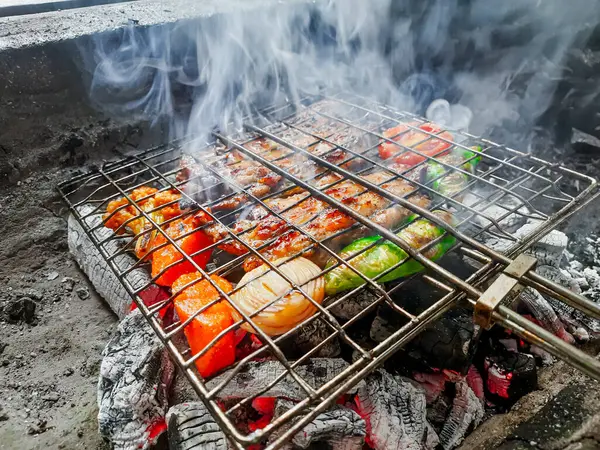 Izgarada, dumanlı ve alevli çeşit çeşit ızgara et. Barbekü şişleri yanan ızgarada sebzeli et kebabı.