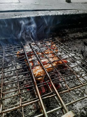 Izgarada, dumanlı ve alevli nefis ızgara et. Barbekü şişleri yanan ızgarada sebzeli et kebabı.