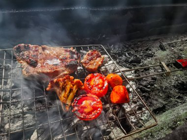 Izgarada, dumanlı ve alevli nefis ızgara et. Barbekü şişleri yanan ızgarada sebzeli et kebabı.