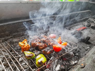 Izgarada, dumanlı ve alevli nefis ızgara et. Barbekü şişleri yanan ızgarada sebzeli et kebabı.