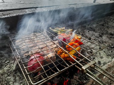 Izgarada, dumanlı ve alevli nefis ızgara et. Barbekü şişleri yanan ızgarada sebzeli et kebabı.