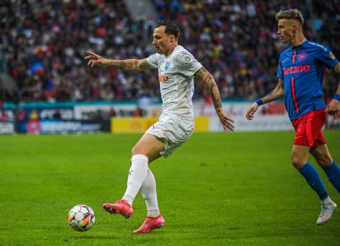 Octavian Popescu (R) ve Gjoko Zajkov (L), 17 Mayıs 2025 'te Bükreş' teki Ulusal Arena 'da düzenlenen Romanya Superliga karşılaşmasında çekildi..