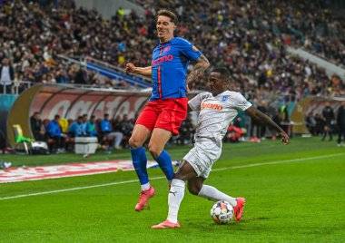 FCSB 'den David Miculescu (L) ve Craiova' dan Basilio Nchama (R), 17 Mayıs 2025 'te Bükreş' teki Ulusal Arena 'da düzenlenen Romanya Superliga karşılaşmasında çekildi..