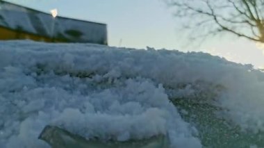 Scraping Ice from Car Window on Frosty Close-up video of a car windshield being scraped clean of ice on a freezing winter morning. The frosted glass and scraper movement highlight the cold weather struggle faced by drivers during icy conditions